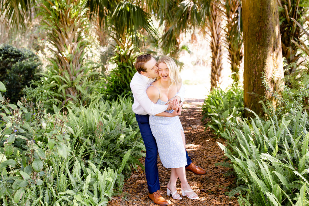 Couple poses beneath the palm trees their Bok Tower Gardens engagement photos
