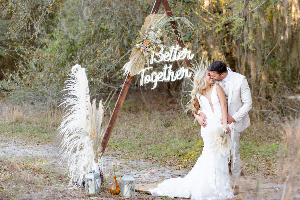 Boho elopement photo with a "Better Together" neon sign