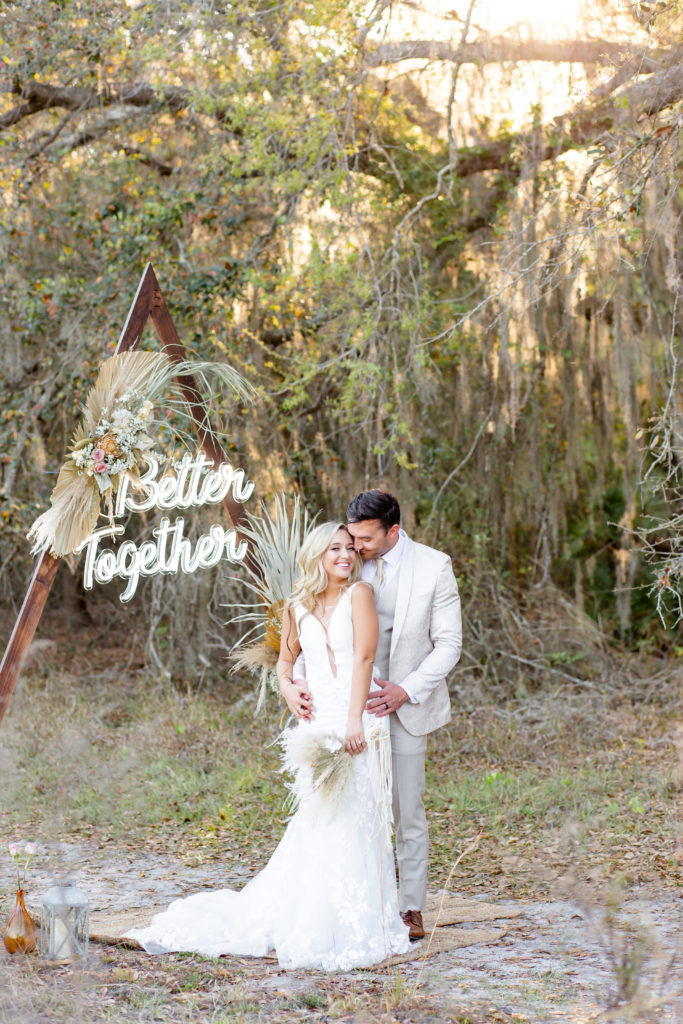 Boho elopement portrait of the bride and groom in front of a pampas grass arch