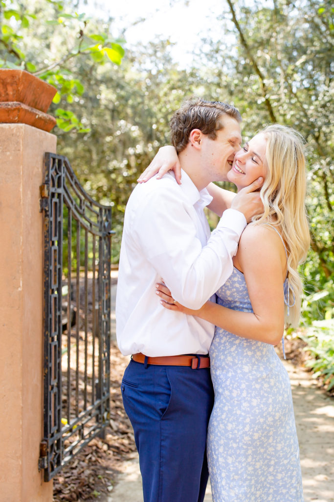 Bok Tower Gardens engagement photos with the engaged couple kissing next to an open gate