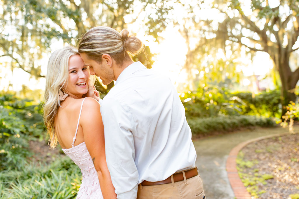 Cypress Grove Park Engagement Photos — Newly engaged couple smiles and laughs with the sun setting in a lush, green park