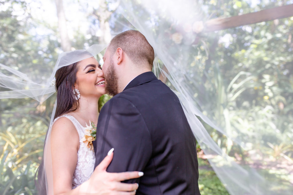 Mead Botanical Garden wedding photo of the couple kissing beneath their veil