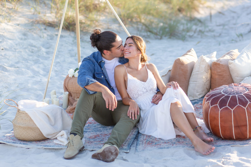 Boho picnic proposal with couple sitting on blanket