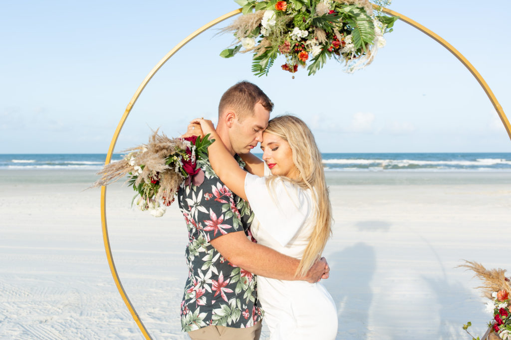 St. Augustine beach wedding photo with a circle arch and tropical attire