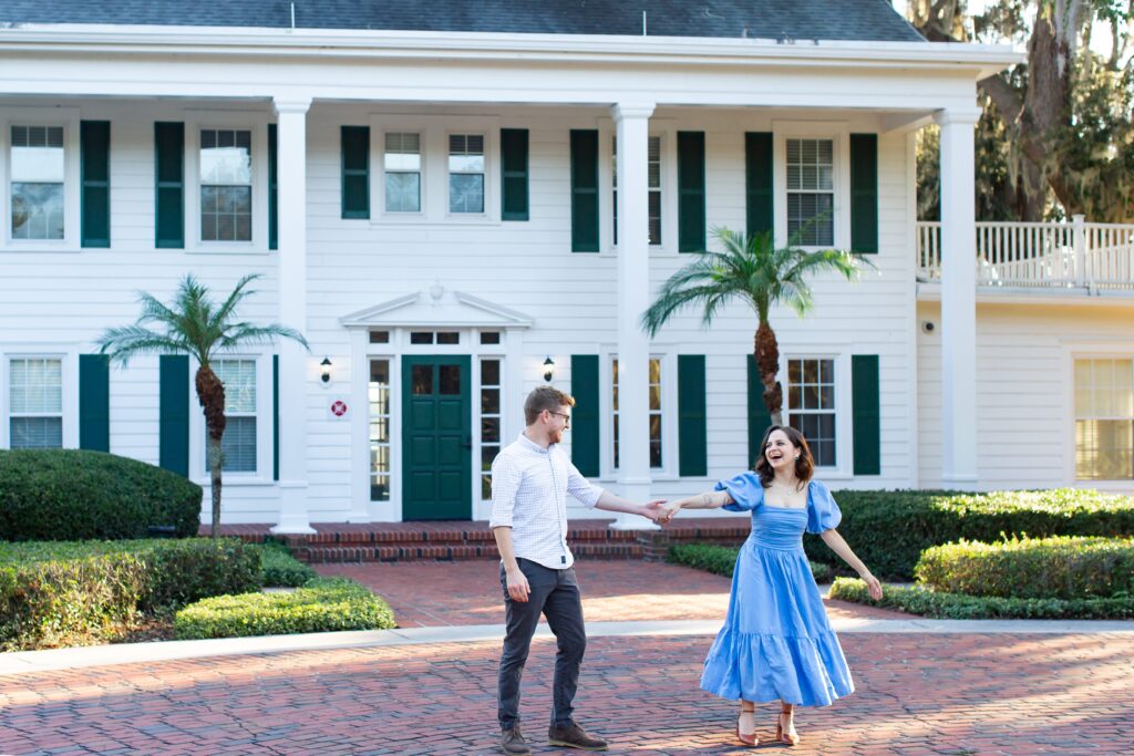 Couple dances in front of Cypress Grove Estate House for their engagement photos at Cypress Grove Park in Orlando, Florida