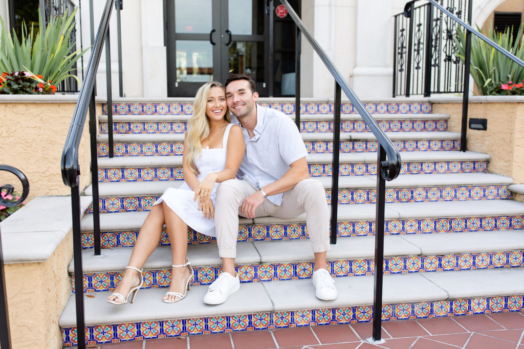 Rollins College engagement photo - an engaged couple sits on the campus stairs