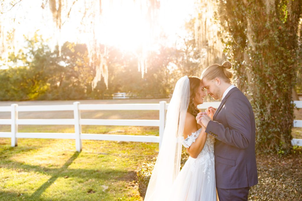 Bramble Tree Estate Wedding: Couple holds hands at sunset on the lawn