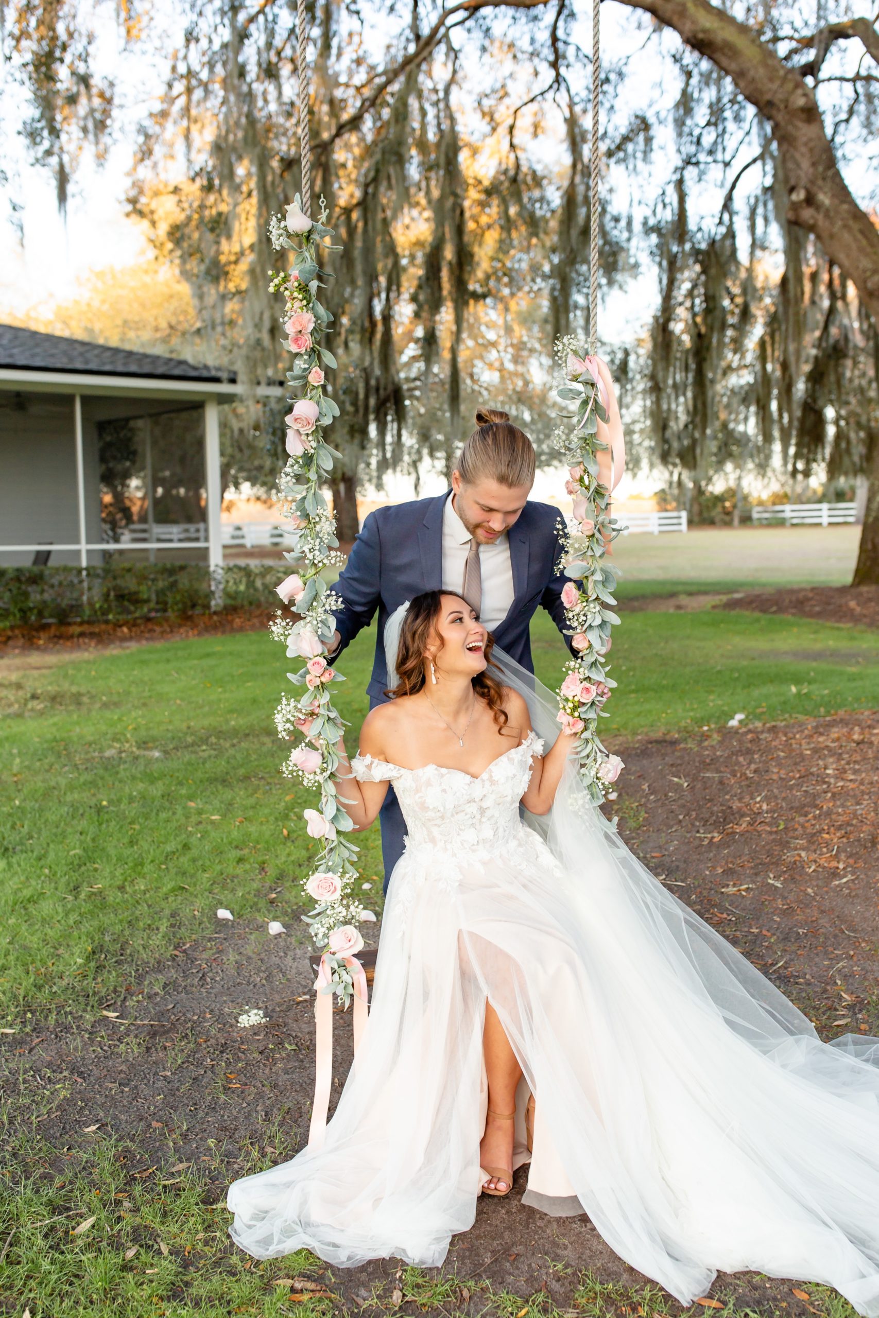Bramble Tree Estate Wedding Photo — Bride and Groom on floral swing under Spanish Moss