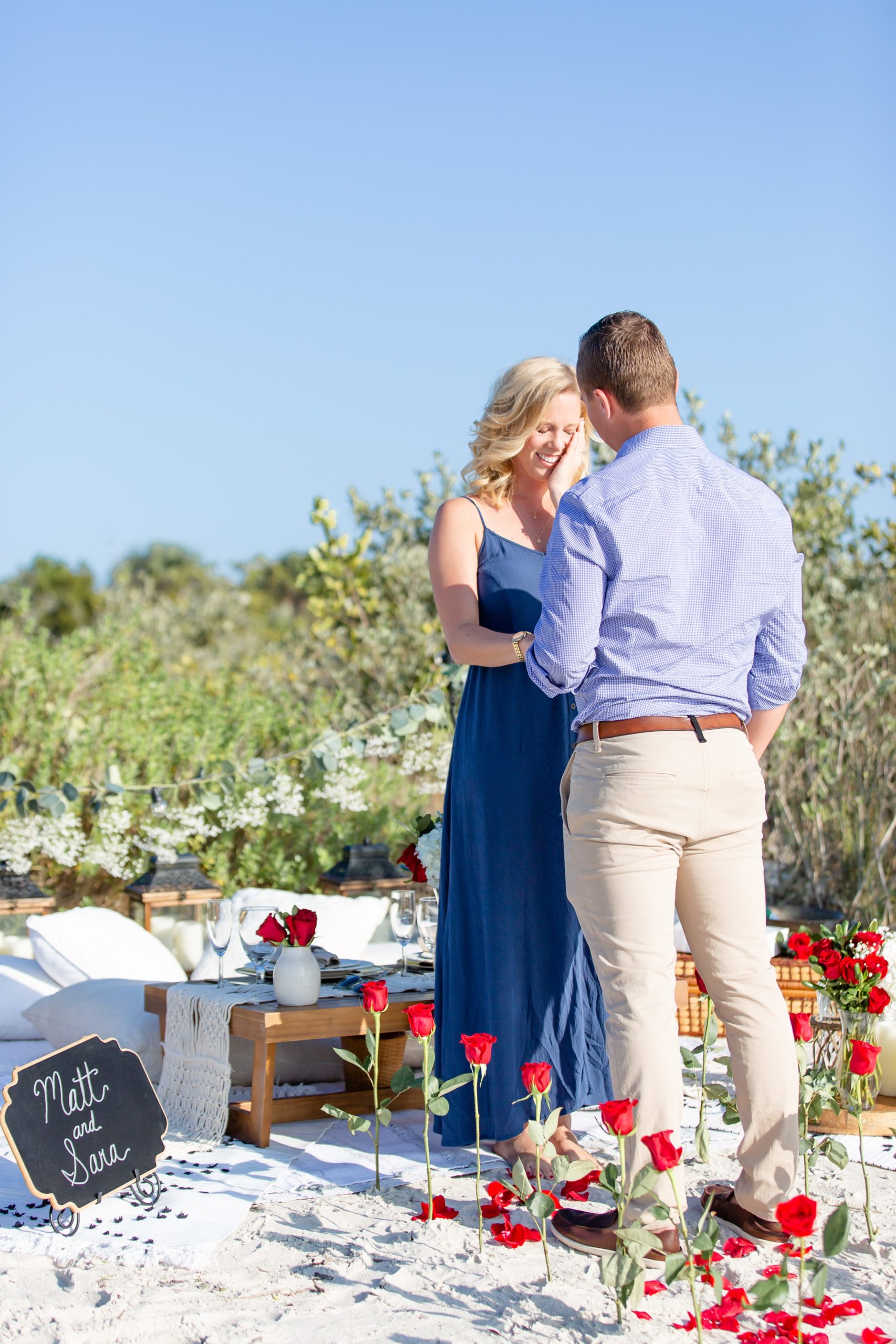 Surprise beach proposal in Florida with a rose petal aisle and sand under their feet