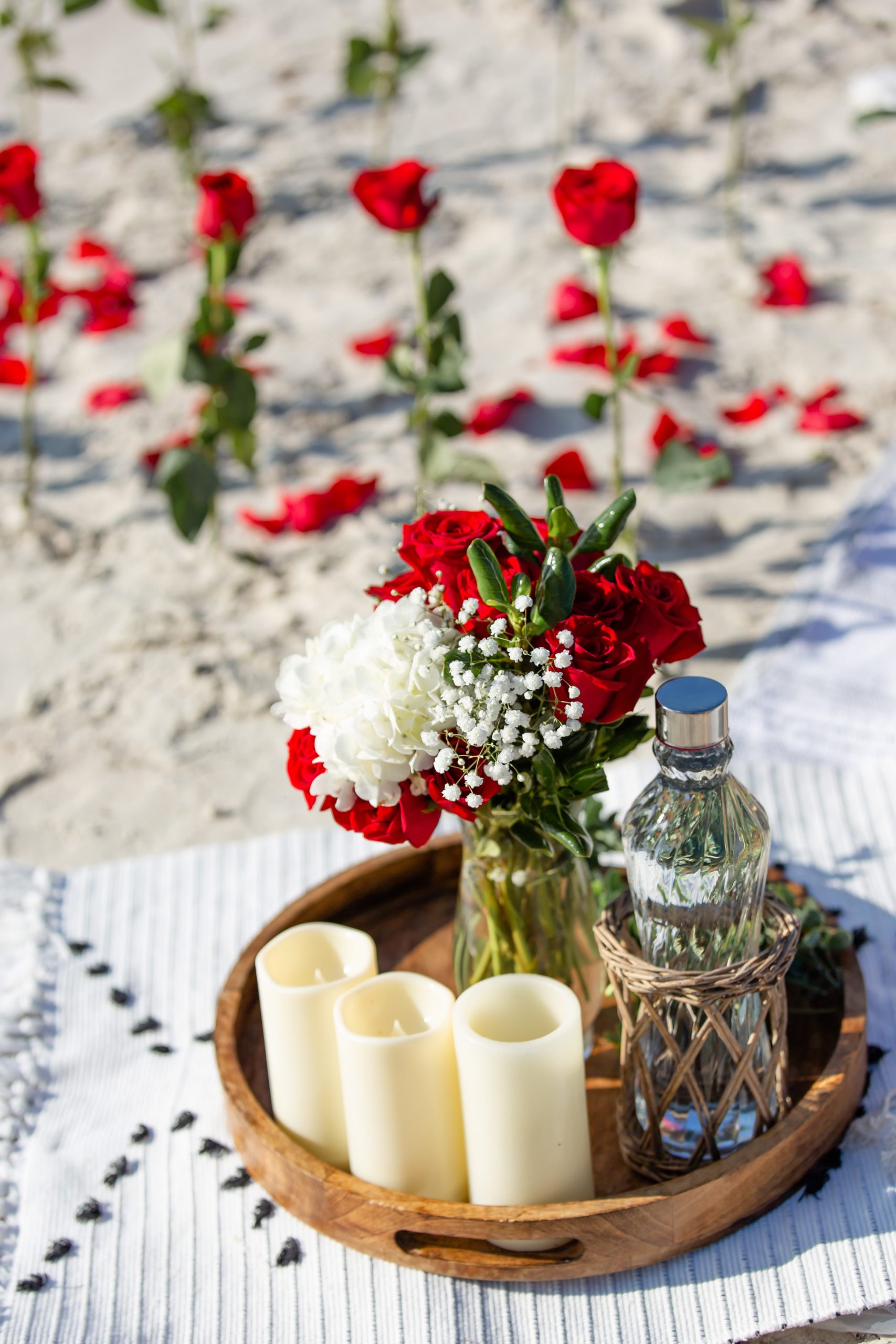Beach proposal with roses, candles and a picnic