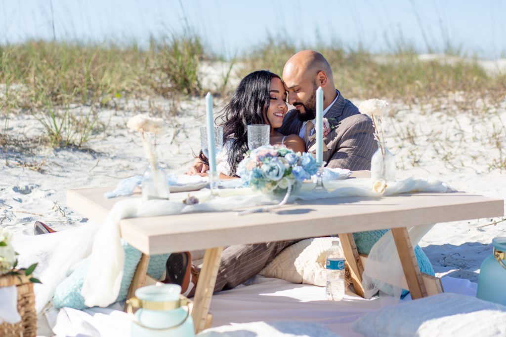 Elopement picnic at New Smyrna Beach with a pastel blue tablescape set up on the sand