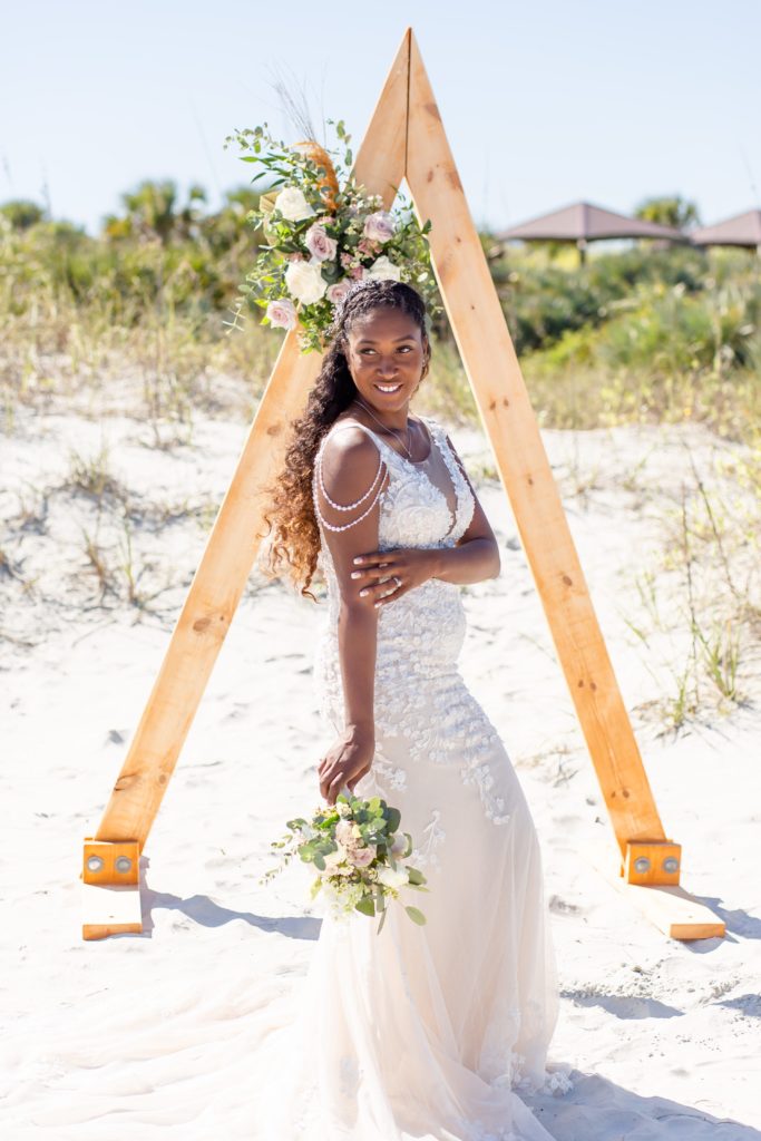 Florida beach wedding with a raw wooden arch and pink florals