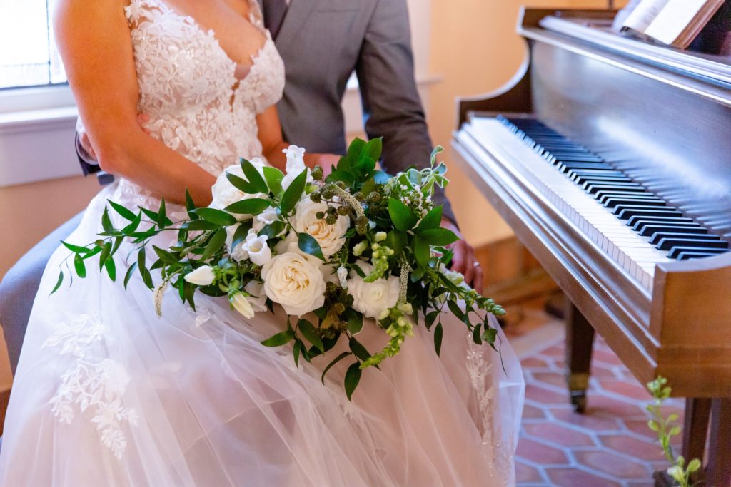 Close-up of a bouquet with a grand piano at Pillars' Castle