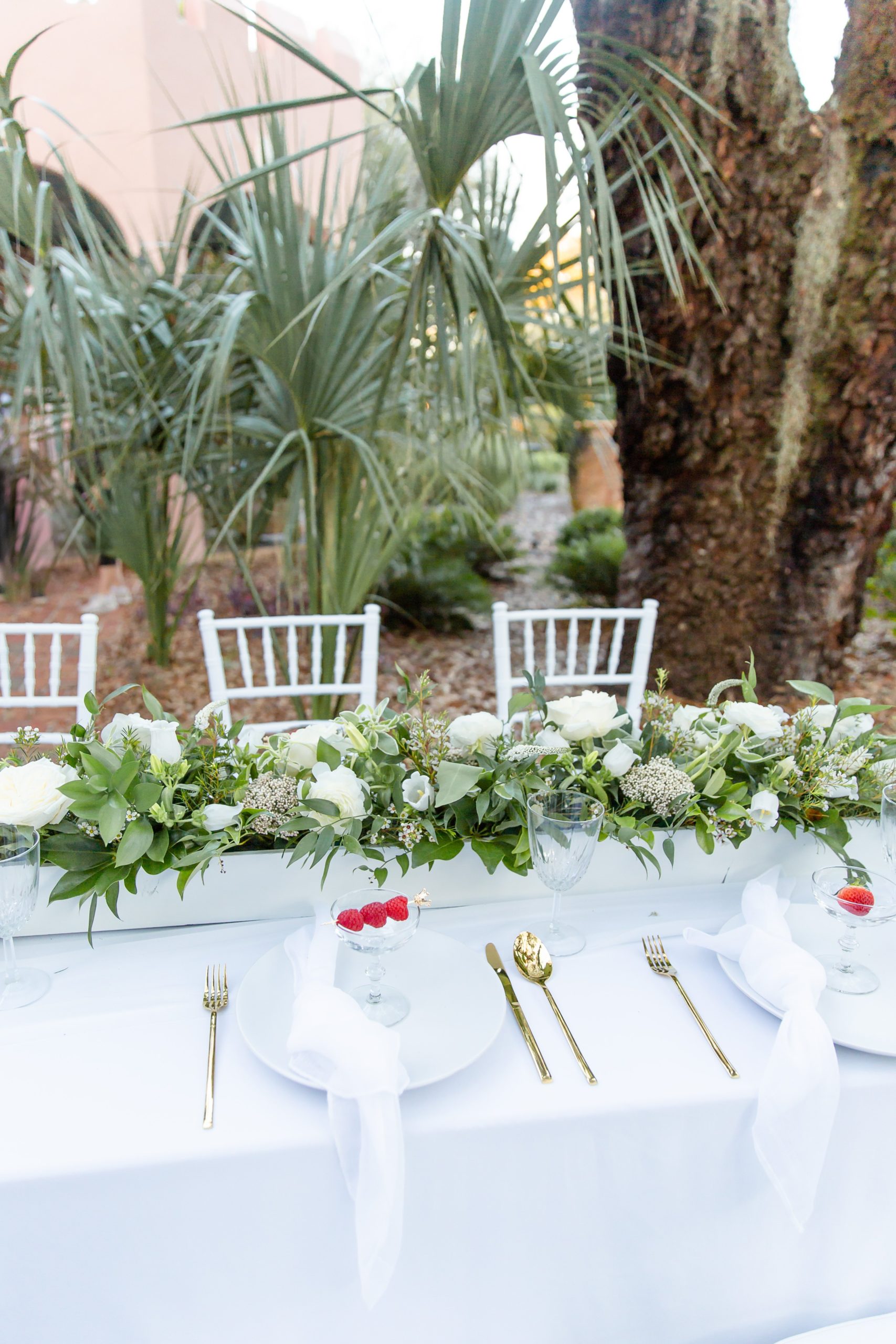 Pillars' Castle family style tablescape under the palm trees