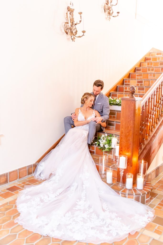 Pillars Castle Wedding Photo — Bride and Groom sitting on castle staircase with candles