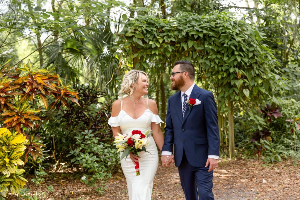 Mead Garden Wedding Photo — Bride and Groom walking under ivy arbor