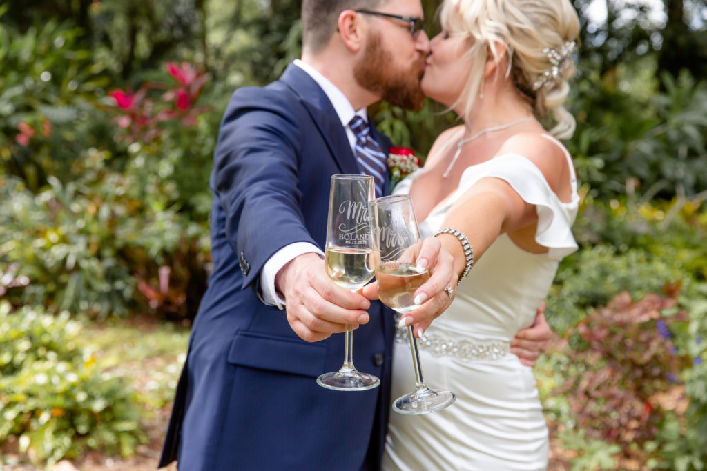 Mead Garden Wedding Photo — Bride and Groom kissing and toasting with champagne in the tropical garden
