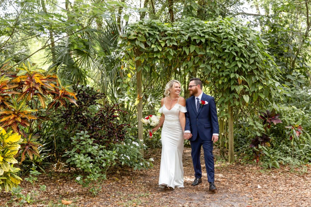 Mead Garden Wedding Photo — Bride and Groom walking under ivy arborMead Botanical Garden Elopement Wedding Photo — Bride and Groom walking under ivy arbor