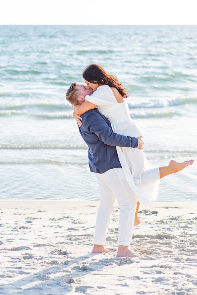 Naples Engagement Photo — Guy lifting girl and kissing on the beach
