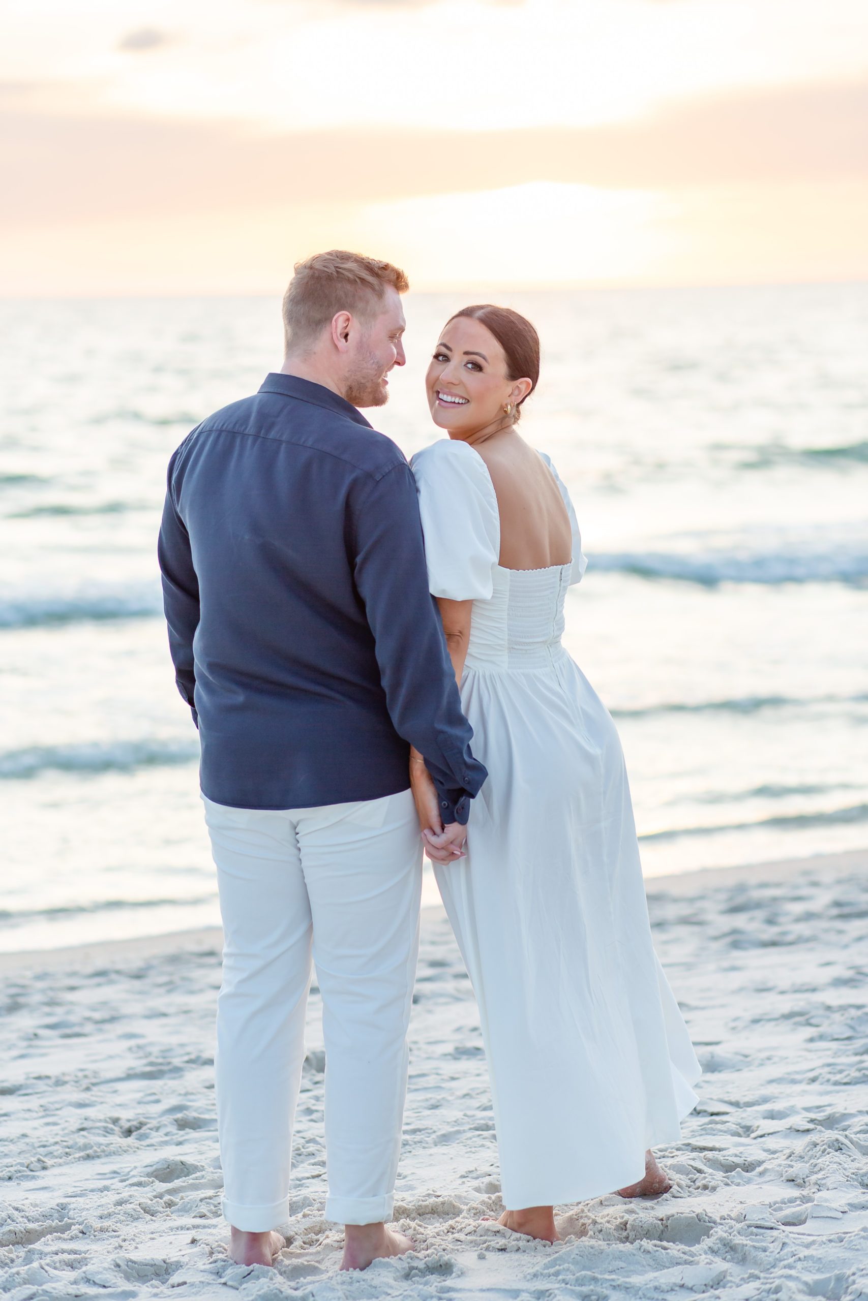 Florida engagement photos at the beach with the sun setting behind the couple