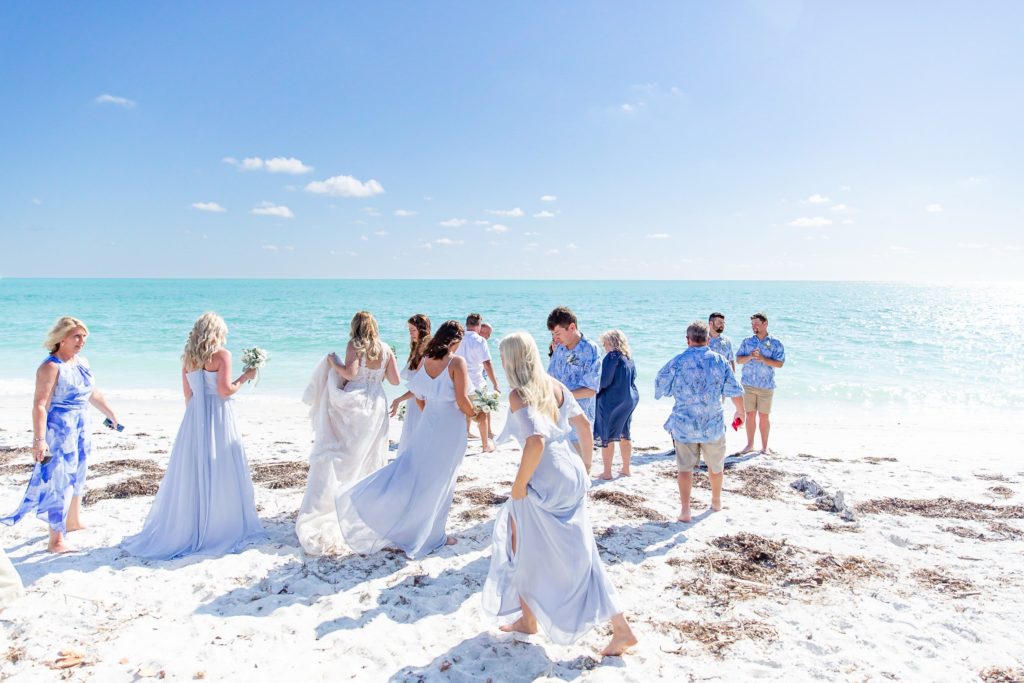 Wedding party in pastel blue attire on the beach