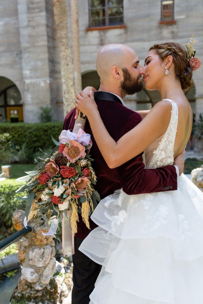 Lightner Museum courtyard wedding photo of the couple with a colorful boho bouquet
