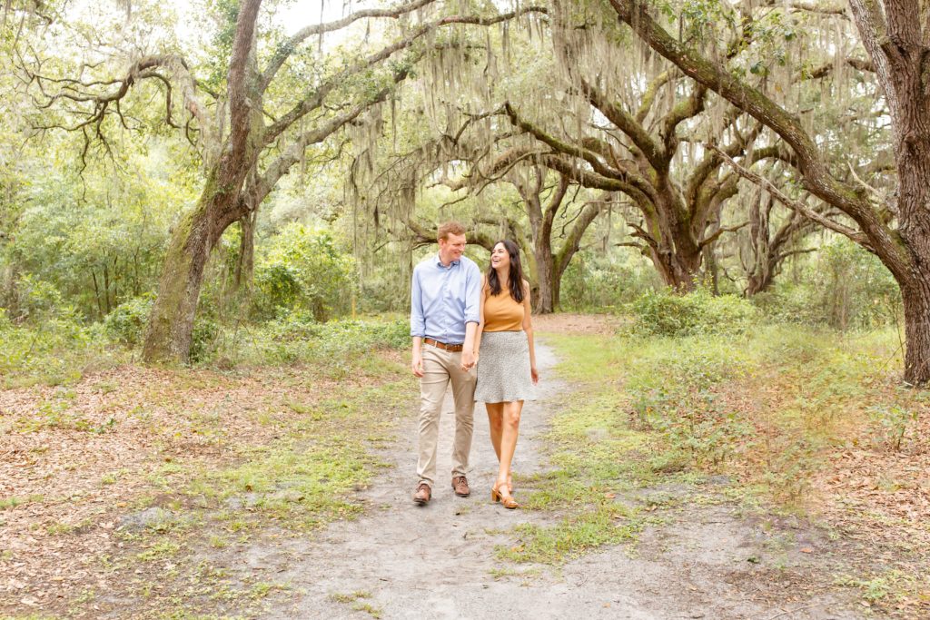 Lake Runnymede Engagement Photo — Guy twirling girl on path of beautiful spanish moss trees