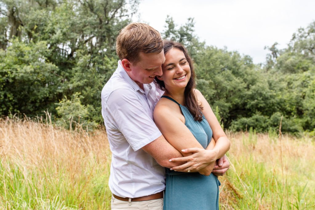 Lake Runnymede Engagement Photo — Couple hugging in field