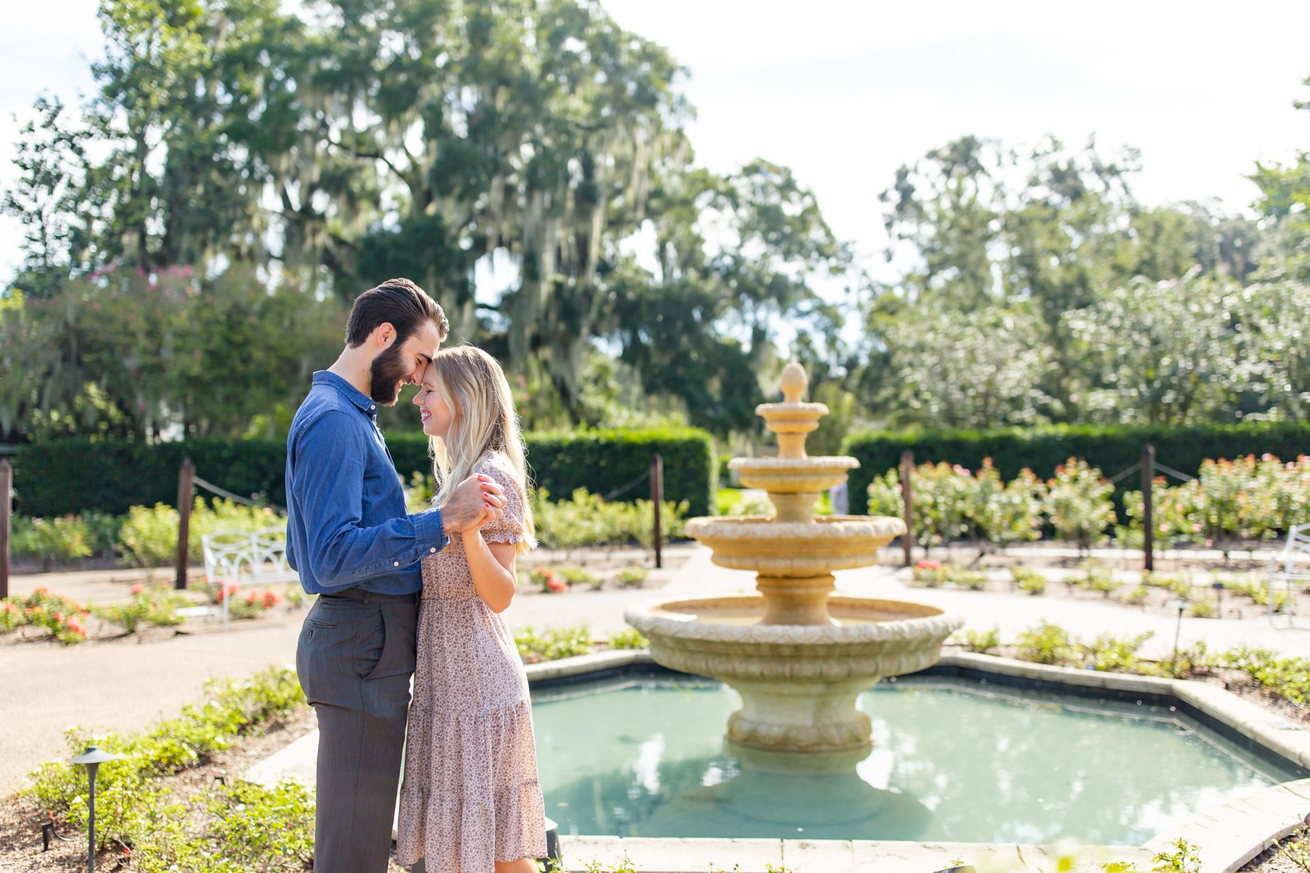 Leu Gardens Engagement Photos in Orlando, FL — Couple standing in front of fountain in rose garden