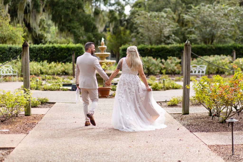 Leu Gardens Wedding Photos in Orlando, FL — Bride and Groom walking to fountain in rose garden