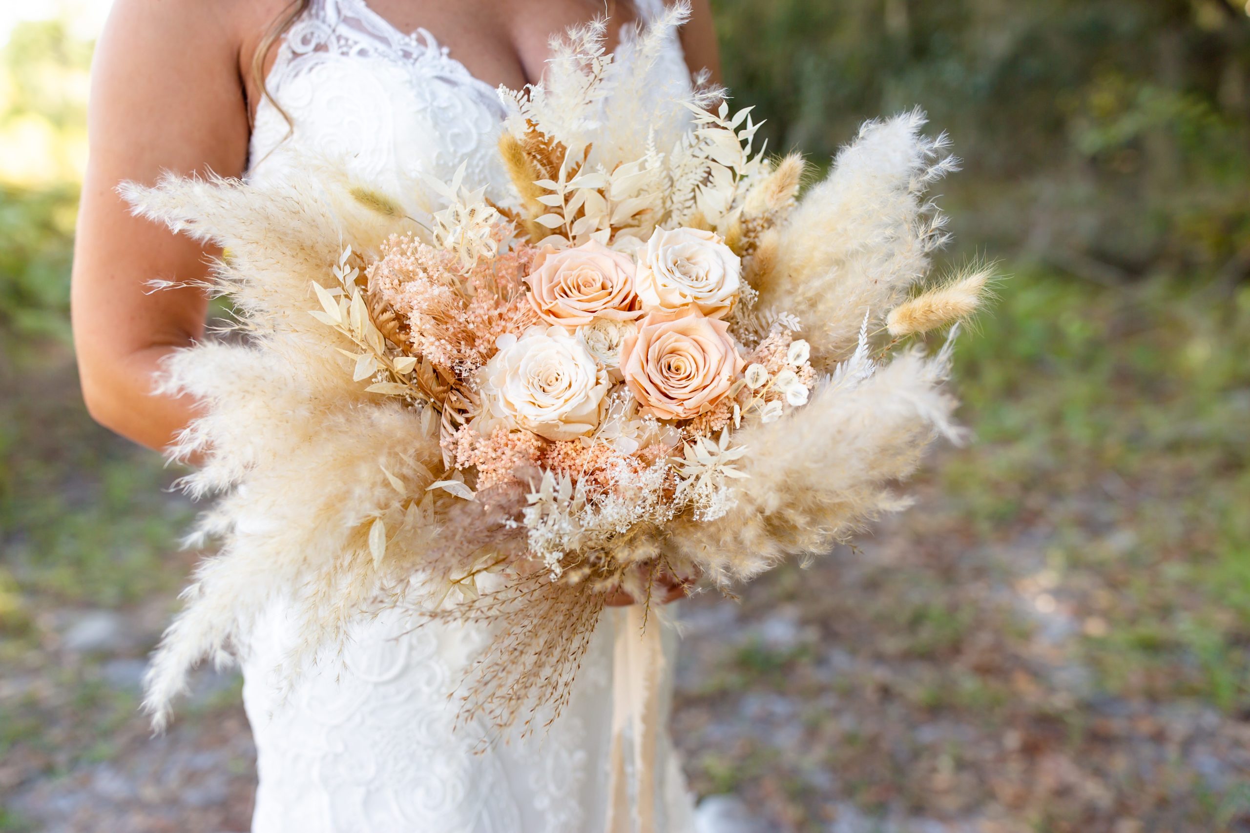 Lake Louisa Wedding Photos in Orlando, FL — Bride holding a dried floral bridal bouquet standing in field