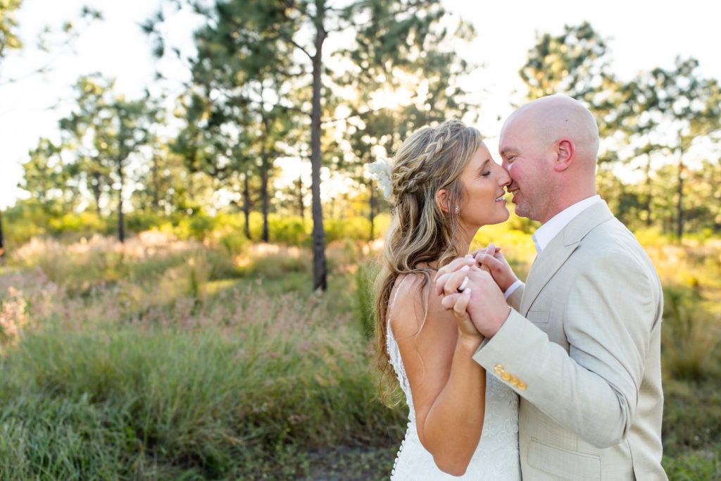 Lake Louisa Wedding Photos in Orlando, FL — Bride and Groom kissing standing in field