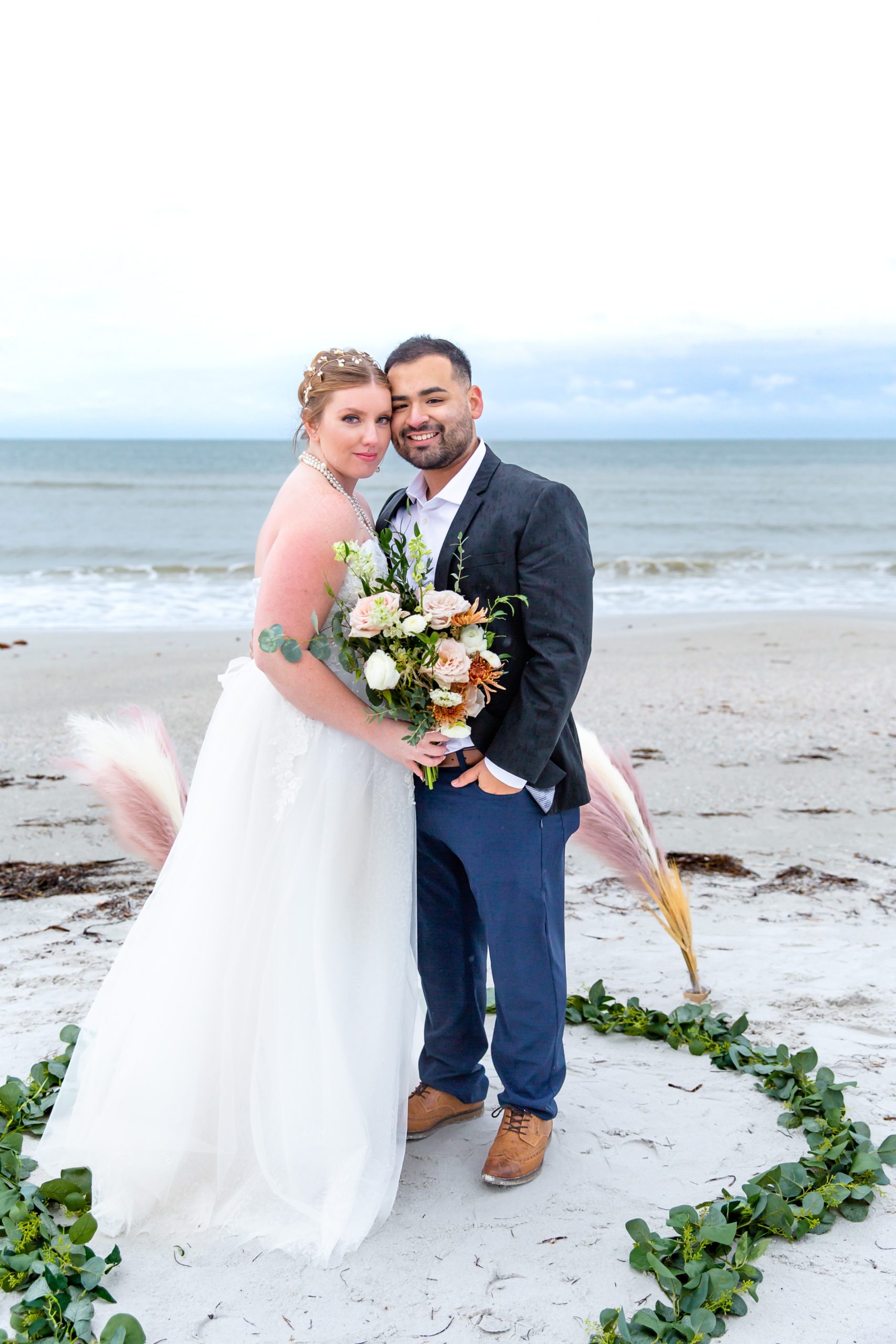 Bride & Groom at beach elopement ceremony with ivy decor in the sand at Treasure Island, Florida