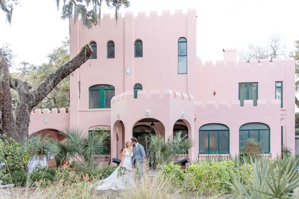 Bride and Groom kissing in front of historic pink castle in St. Augustine, FL