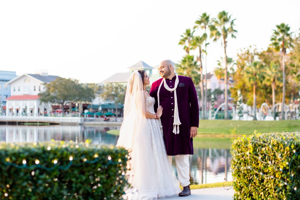 Bride and Groom standing by lake in front of Celebration Florida Bohemian Hotel
