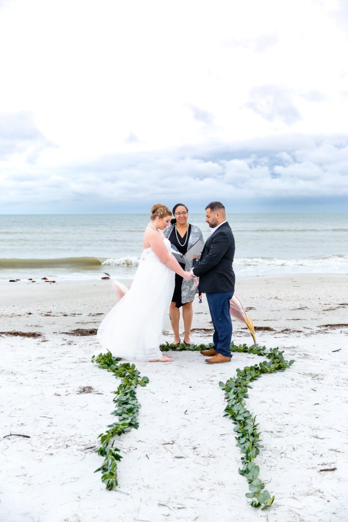 Bride & Groom at beach elopement ceremony with ivy path in the sand