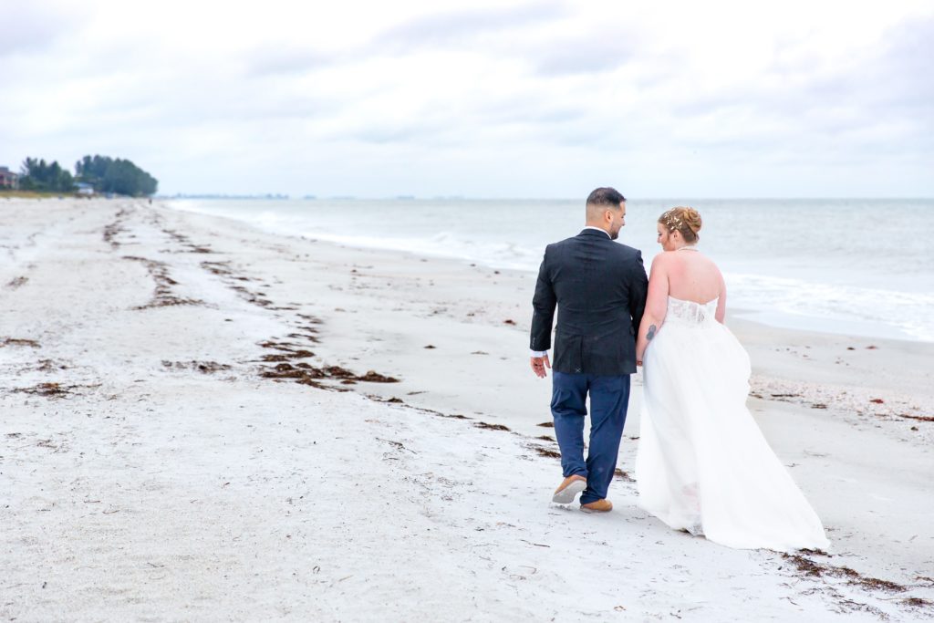 Bride & Groom walking on the beach after their elopement