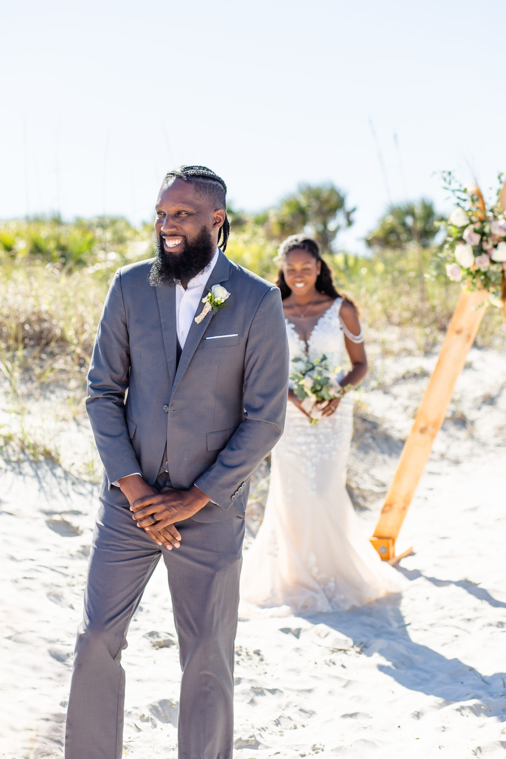 Groom in gray suit with white shirt on the beach