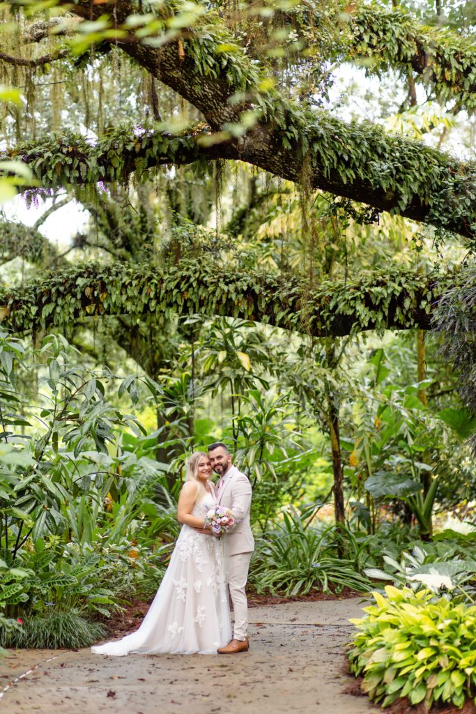 Bride & Groom standing under large tree at Leu Gardens in Orlando