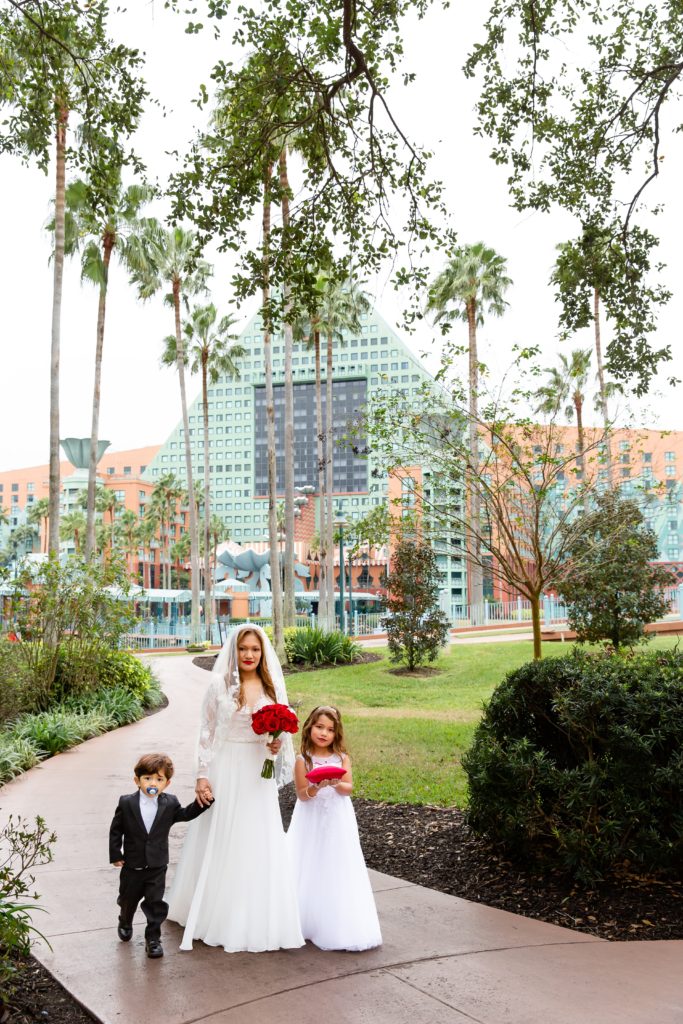 Bride walking down the aisle with son and daughter at the Disney Swan Resort in Orlando, FL