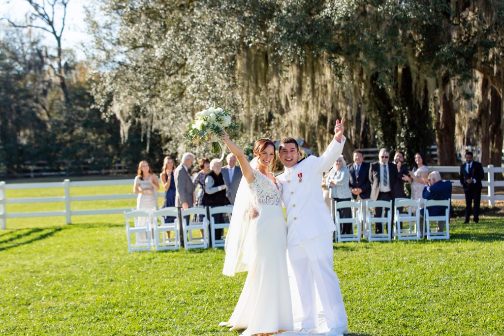 Bride and Groom celebrating marriage as guests watch with beautiful live oak tree backdrop after intimate wedding at Bramble Tree Estate in Orlando, Florida