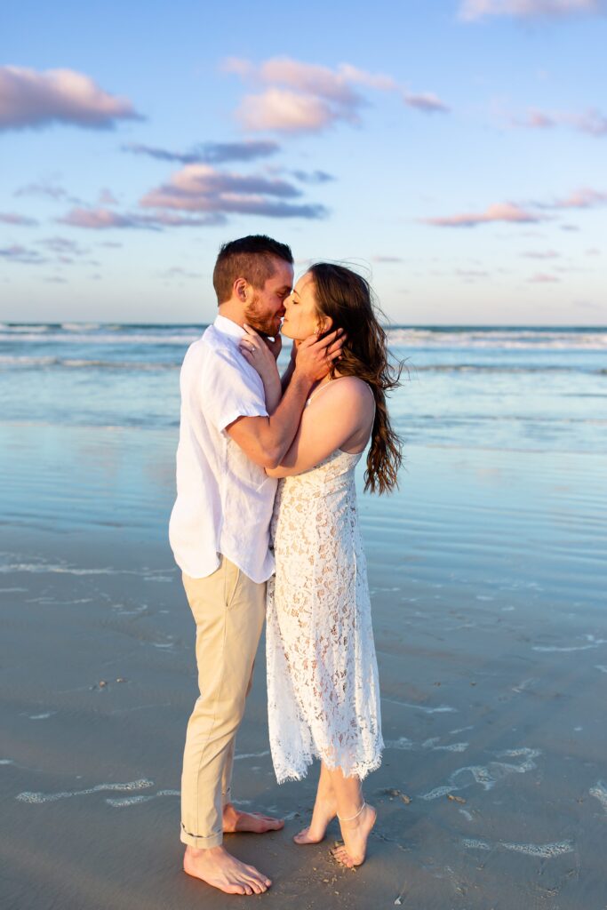 New Smyrna Beach Engagement Photo — Couple kissing on the beach at sunset