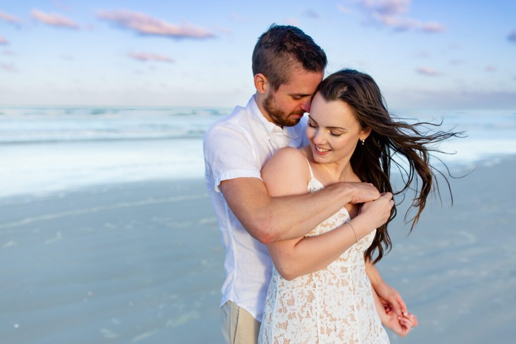 New Smyrna Beach Engagement Photo — Couple snuggled on the beach at sunset