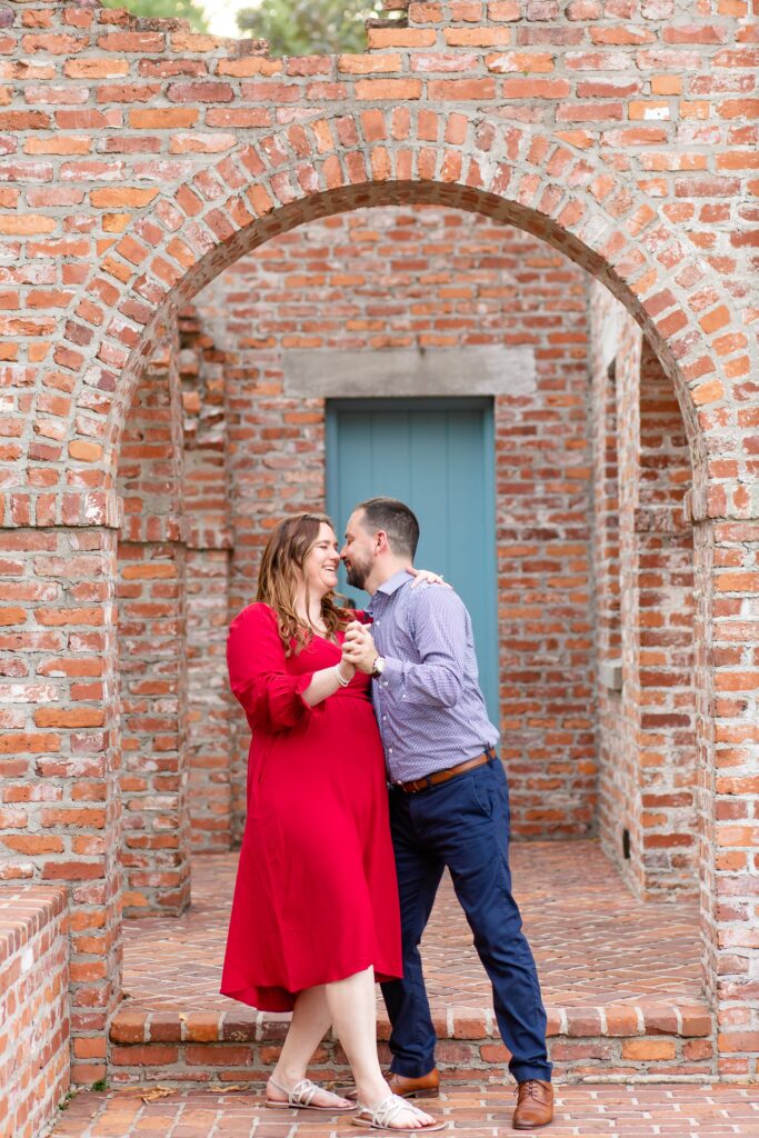 Casa Feliz Historic Home Orlando Engagement Photos — Guy dipping girl and kissing her under brick arch in Spanish historic home in Winter Park, Florida