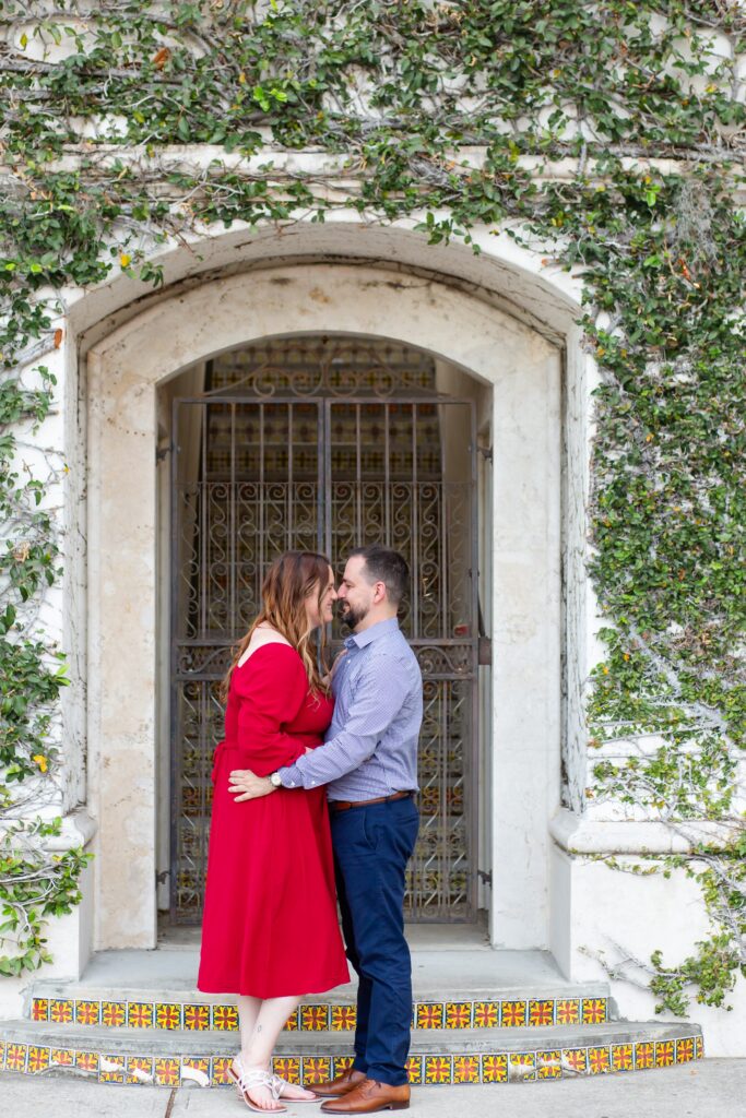Hannibal Square Orlando Engagement Photos — Couple kissing in front of Ivy Wall in Winter Park, Florida