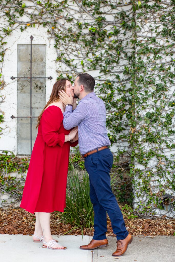 Hannibal Square Orlando Engagement Photos — Couple kissing in front of Ivy Wall in Winter Park, Florida