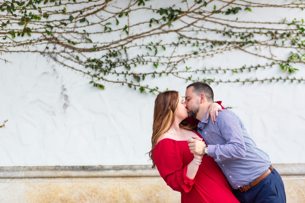 Hannibal Square Orlando Engagement Photos — Guy dipping girl and kissing her in front of Ivy Wall in Winter Park, Florida