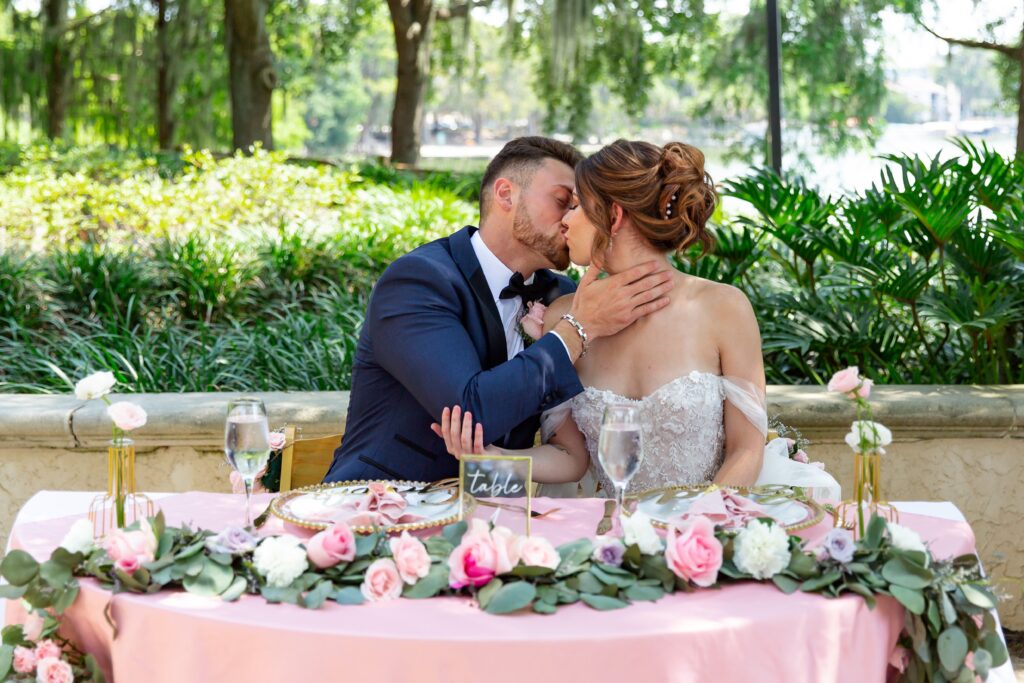 Bride and Groom kissing at sweetheart table at Rollins College in Winter Park Florida after their elopement