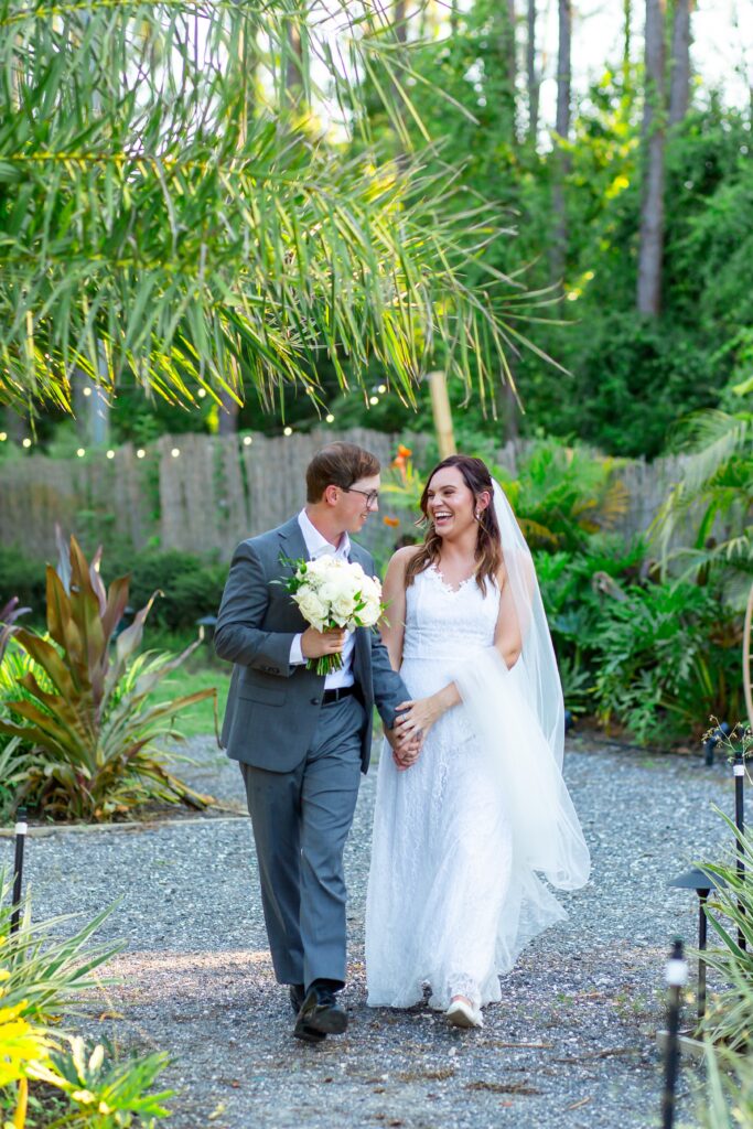 Bride and Groom walking in tropical garden at sunset at the Pinery wedding venue in Florida