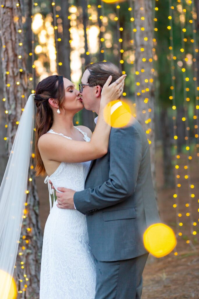 Bride and Groom kissing under magical twinkle lights at Forest Wedding Venue in Florida